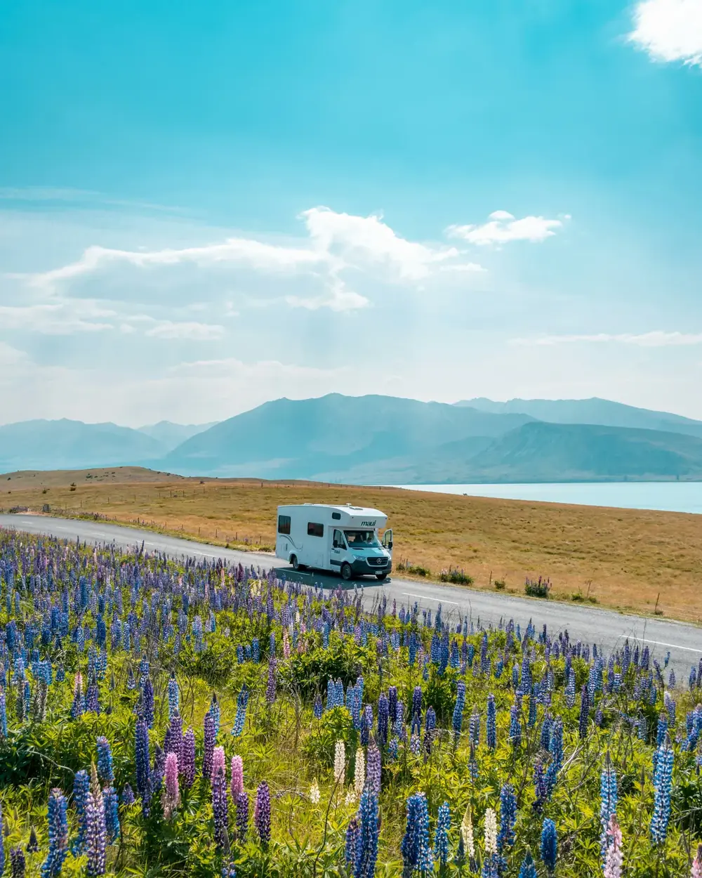 Campervan driving through scenic New Zealand mountains and lake